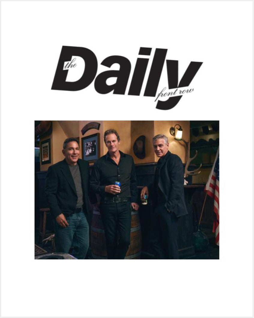 Three men (Mike Meldman, Rande Gerber, George Clooney) standing in a dimly lit bar holding drinks beneath the masthead 'the Daily front row'