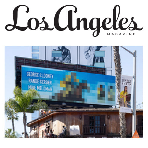Los Angeles Magazine masthead above a billboard on Sunset Boulevard with palm trees and a small wooden building