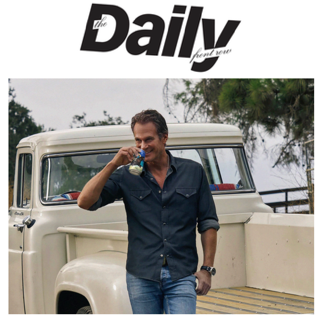 Man (Rande Gerber) drinking a Crazy Mountain non-alcoholic beer can while leaning against a vintage white pickup truck outdoors