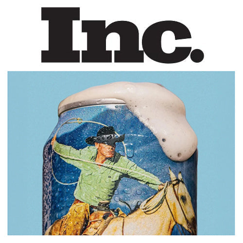 Close-up of a beer can with cowboy artwork topped with foam under headline “Inc.” on a light blue background