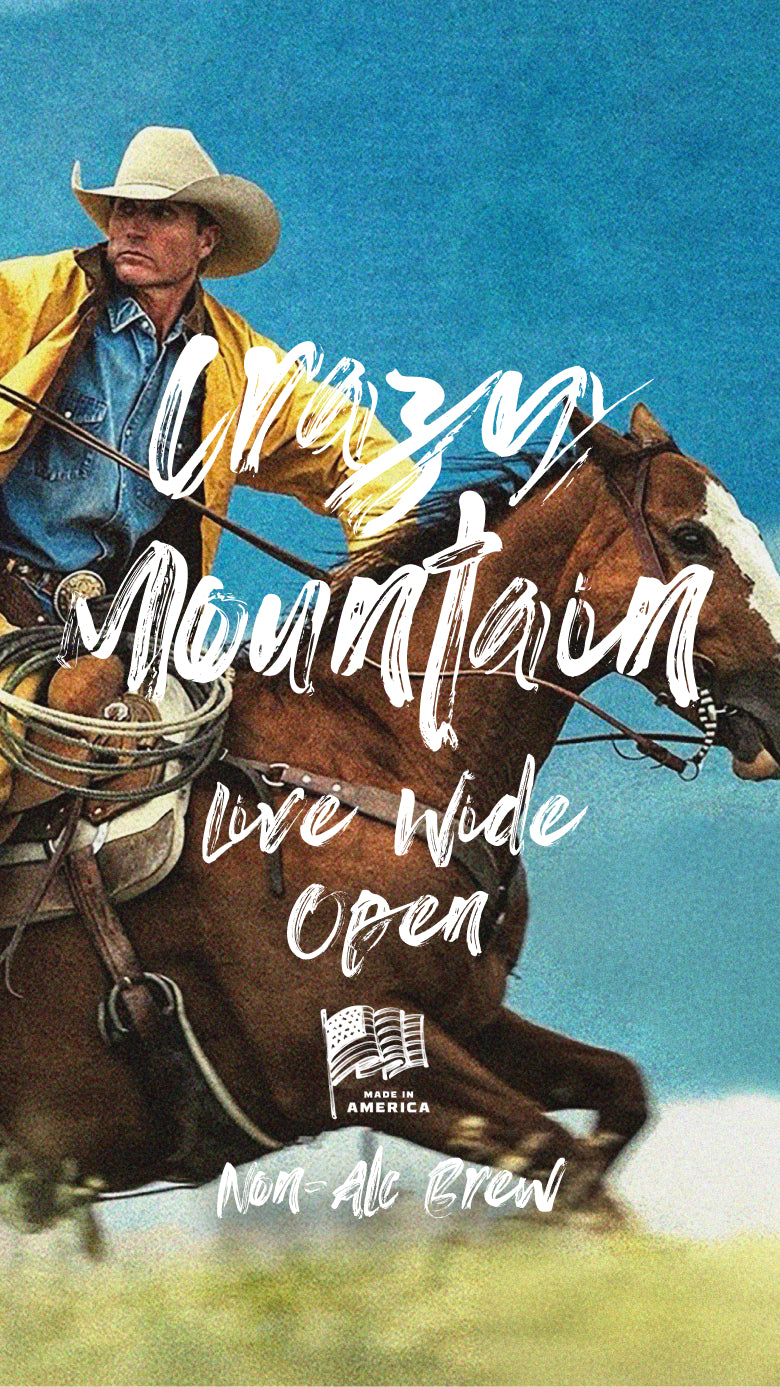 cowboy in yellow jacket looking over his right shoulder while riding a horse in a grassy open field with bridle in hand and lasso on his lap. Words Crazy Mountain appear in white brush strokes, along with 'Live Wide Open' and 'Made in America Non-Alc Brew' below an American flag. Mobile version of image. 