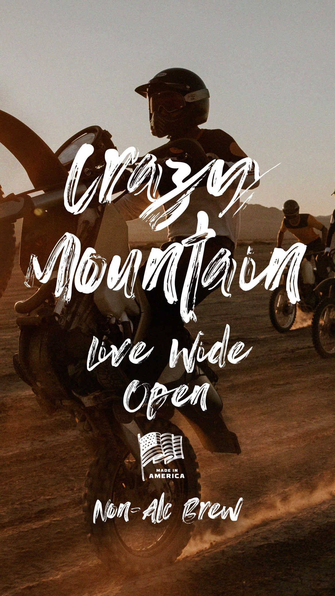 Motorcycle rider doing a wheelie at sunset; overlaid text: 'Crazy Mountain Live Wide Open MADE IN AMERICA Non-Alc Brew'