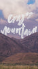 Cowboy rides horse across a mountain background, lassoing a rope. Behind the mountains shows 'Crazy Mountain' in white brushstrokes text. 