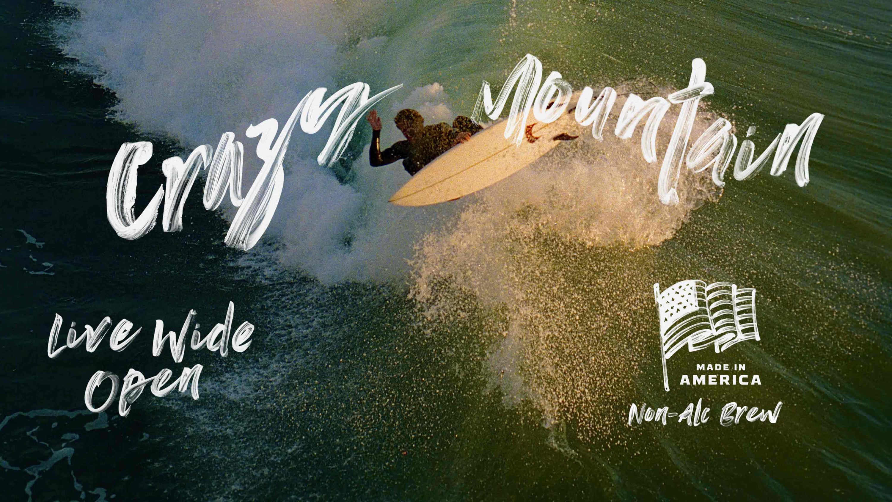 Surfer riding a breaking wave with white brushstroke Crazy Mountain headline and Live Wide Open overlay